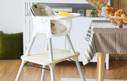A child's high chair sits beside the table